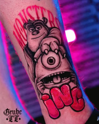 Neonowy tatuaż potworów z Monsters, Inc. na łydce: niebieski Sully z rogami i fioletowy Mike z jednym okiem, logo studia w różu, świecące kolory z grubymi konturami, wesoła poza.